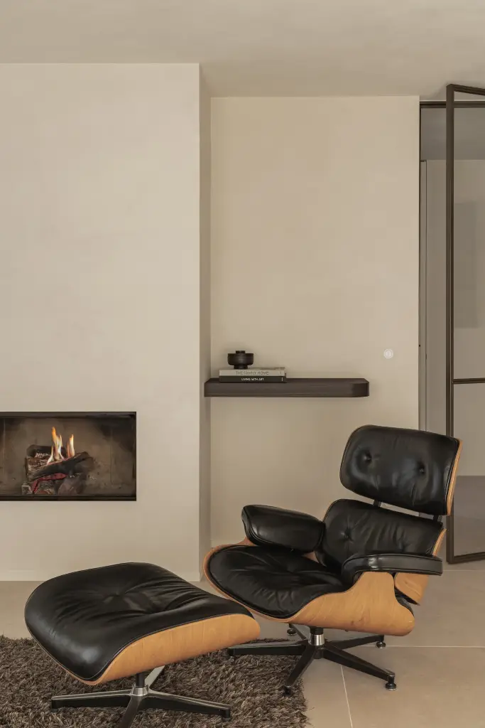 Leeshoek met zwarte lounge fauteuil, gashaard en zwevend tablet, Villa in Loppem, interieur Laura Calleeuw