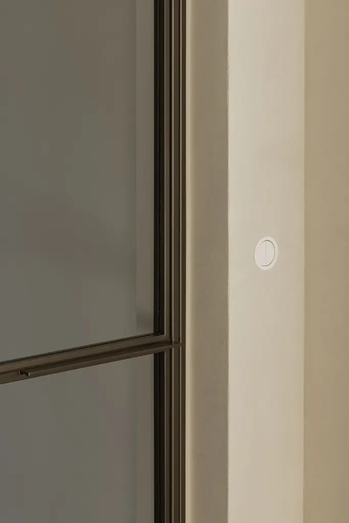 Detail van een stalen deurkader met glas en stopcontact, Villa in Loppem, interieur Laura Calleeuw