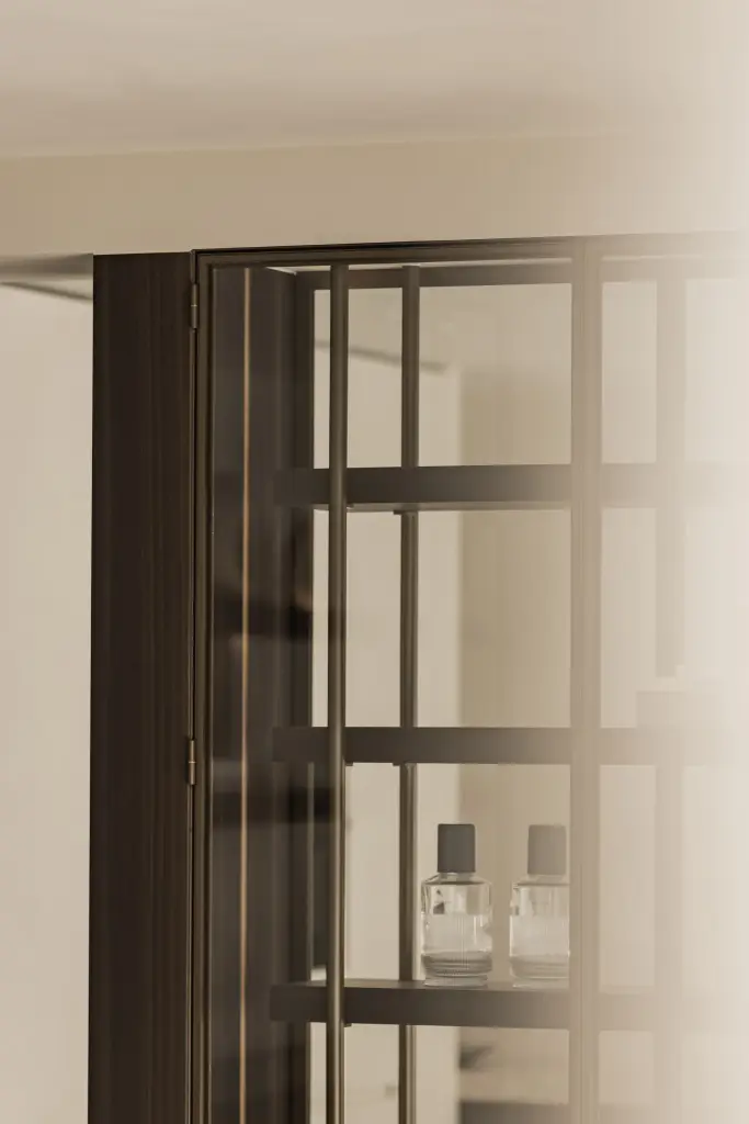 Stalen vitrinekast met glas, planken en natuurstenen sokkel, Villa in Loppem, interieur Laura Calleeuw
