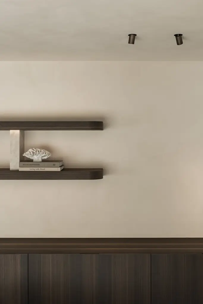 Zwevende wandplanken in donker hout op natuurstenen consoles boven een dressoir, Villa in Loppem, interieur Laura Calleeuw