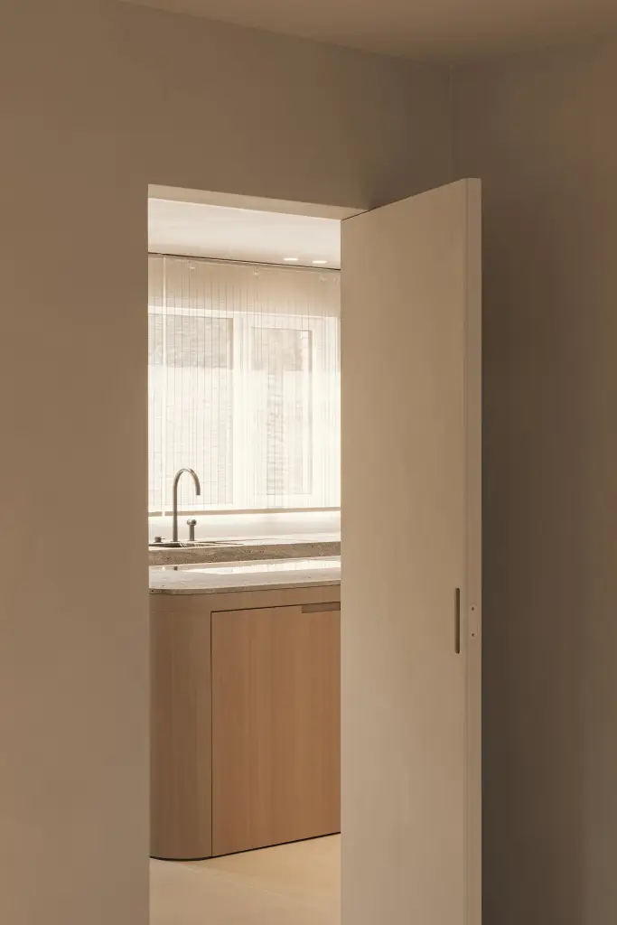 Doorkijk naar de keuken door een open deur, Totaalrenovatie in Loppem, interieur Laura Calleeuw