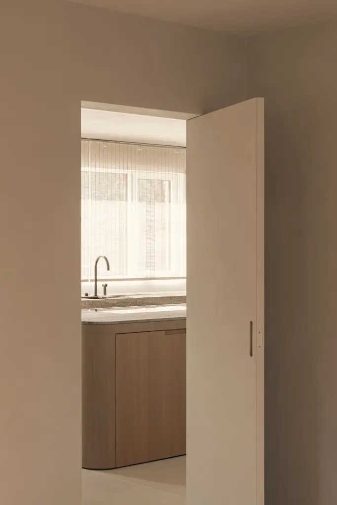 Doorkijk naar de keuken door een open deur, Totaalrenovatie in Loppem, interieur Laura Calleeuw