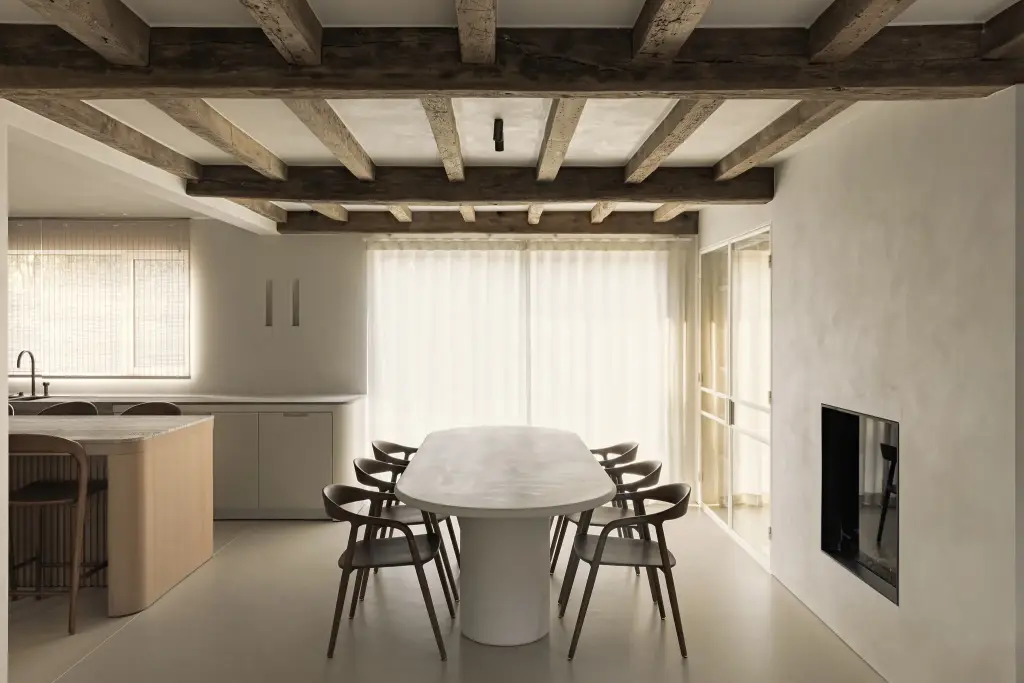 Eethoek met ovale tafel, houten balkenplafond en gashaard, Totaalrenovatie in Loppem, interieur Laura Calleeuw