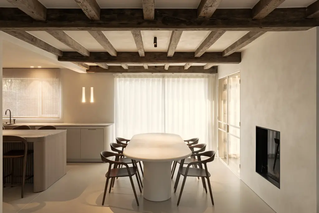 Eethoek met ovale tafel, houten balkenplafond en gashaard, Totaalrenovatie in Loppem, interieur Laura Calleeuw
