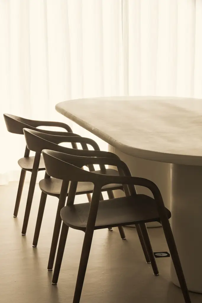 Zwarte houten eetstoelen aan een ovale tafel, Totaalrenovatie in Loppem, interieur Laura Calleeuw