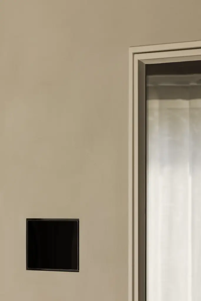 Zwarte inbouwhaard in een wand met stucwerk, Totaalrenovatie in Loppem, interieur Laura Calleeuw