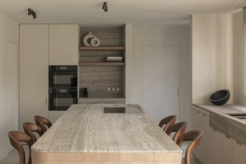 Keuken met travertijn kookeiland, ovenkast en leren stoelen, Totaalrenovatie in Loppem, interieur Laura Calleeuw