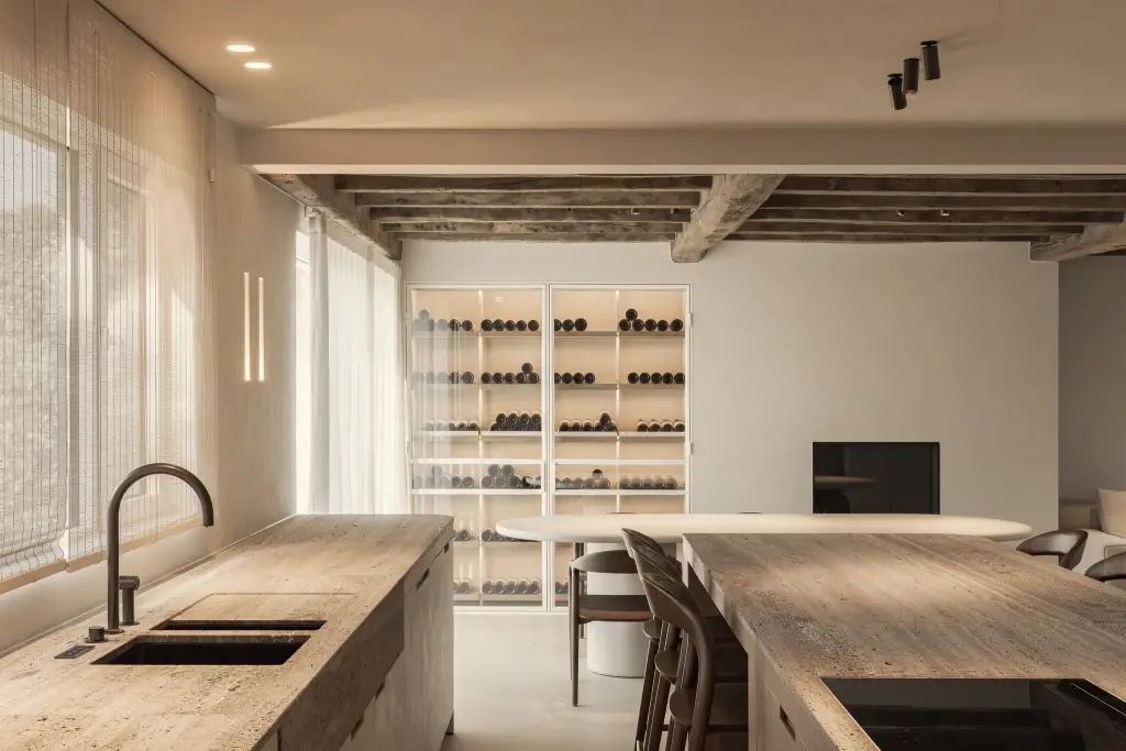Keuken met travertijn eiland, spoelbak en glazen wijnkast, Totaalrenovatie in Loppem, interieur Laura Calleeuw
