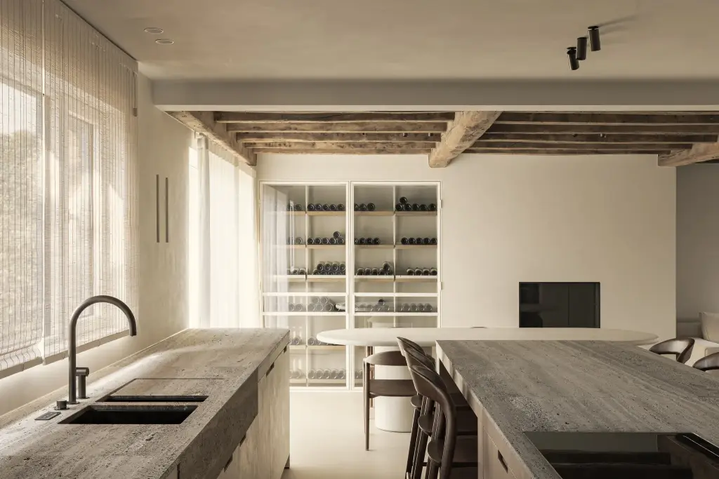 Keuken met travertijn eiland, spoelbak en glazen wijnkast, Totaalrenovatie in Loppem, interieur Laura Calleeuw