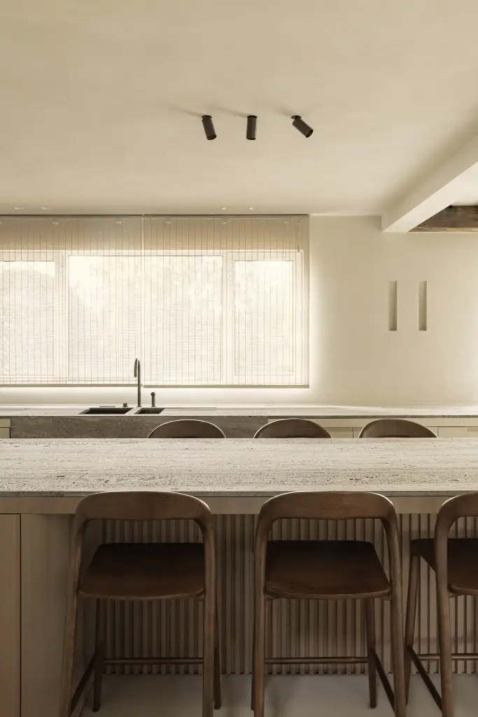Keukeneiland met barkrukken en spots voor het raam met bamboe rolgordijn, Totaalrenovatie in Loppem, interieur Laura Calleeuw