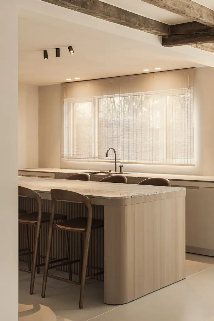 Keukeneiland in eiken met travertijn blad onder een plafond met eikenhouten balken, Totaalrenovatie in Loppem, interieur Laura Calleeuw