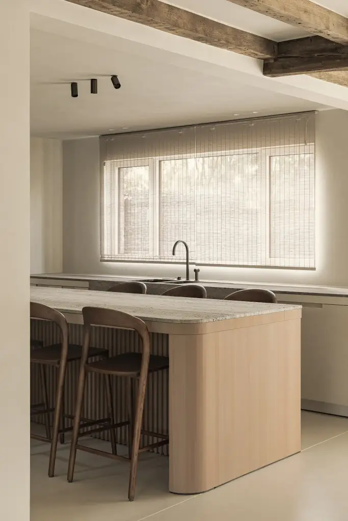 Keukeneiland in eiken met travertijn blad onder een plafond met eikenhouten balken, Totaalrenovatie in Loppem, interieur Laura Calleeuw