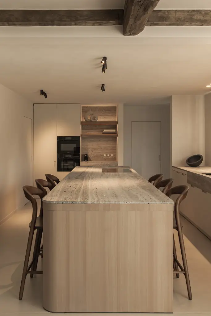 Keukeneiland in eiken met travertijn blad onder een plafond met eikenhouten balken, Totaalrenovatie in Loppem, interieur Laura Calleeuw