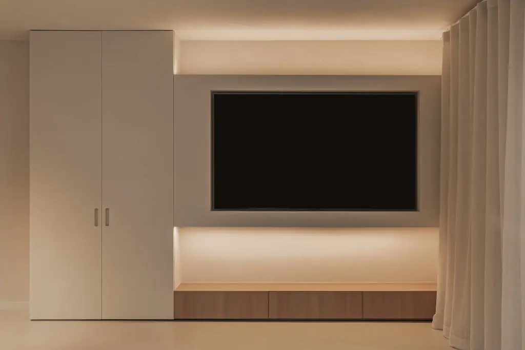 Televisiewand met kastenwand, indirecte verlichting en linnen gordijn, Totaalrenovatie in Loppem, interieur Laura Calleeuw