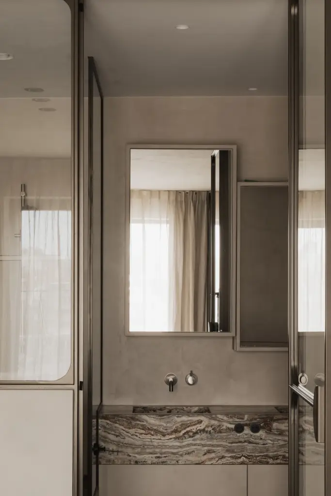 Doorkijk naar de badkamer met onyx wastafel en spiegel, Appartement in Knokke, interieur Laura Calleeuw