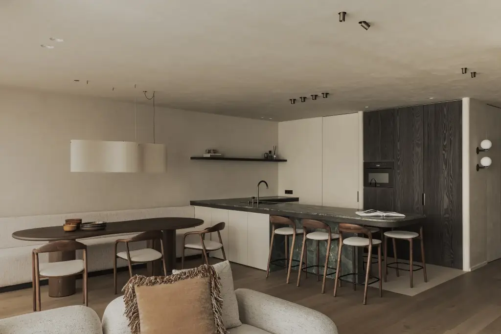 Eethoek met ovale tafel, houten stoelen, zitbank en ronde hanglamp, Appartement in Knokke, interieur Laura Calleeuw