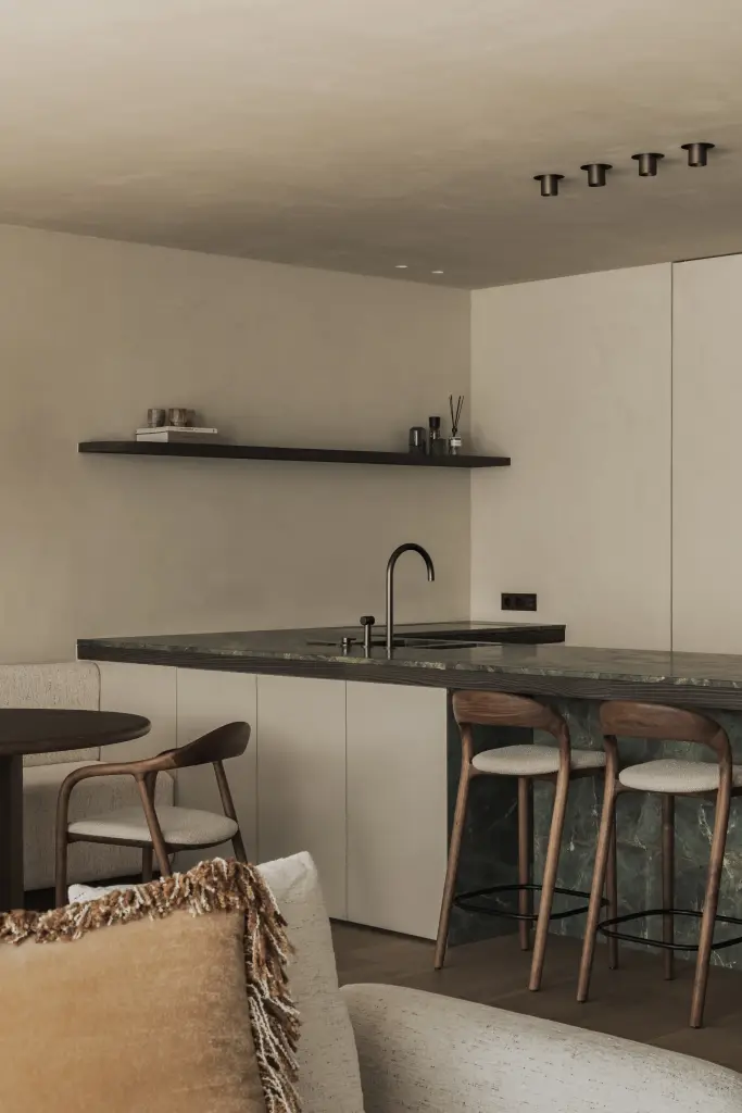 Eethoek met ovale tafel, houten stoelen, zitbank en ronde hanglamp, Appartement in Knokke, interieur Laura Calleeuw
