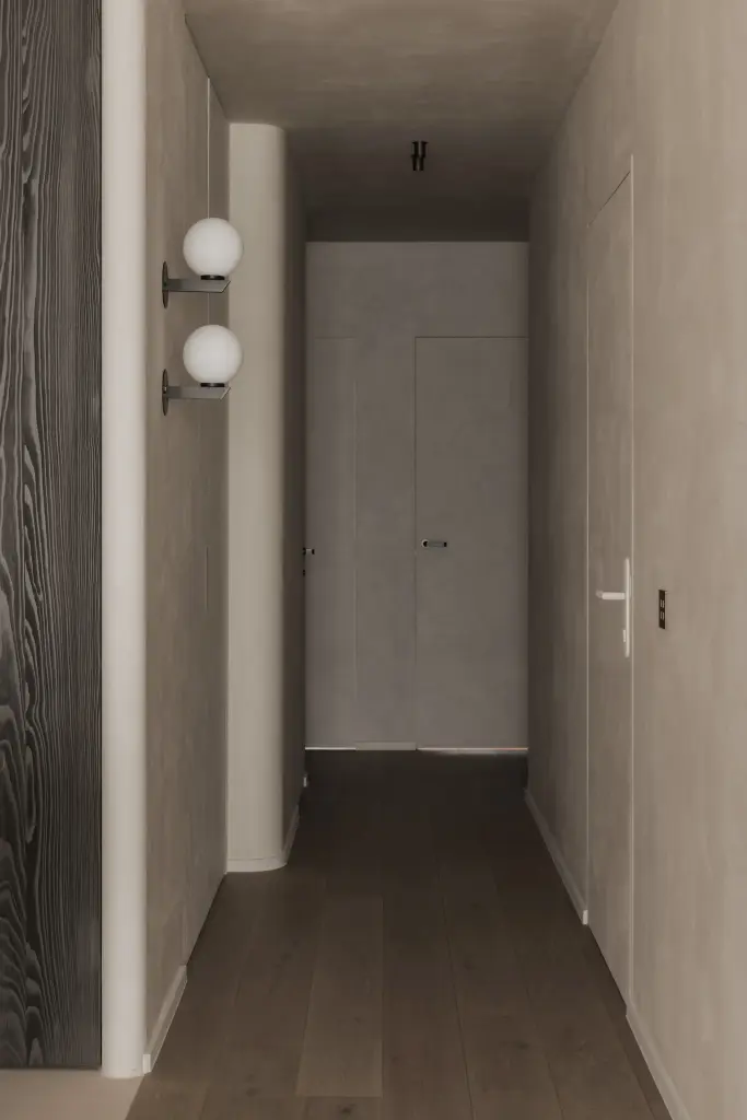 Gang met bolvormige wandlampen, donker houten wand en inbouwkasten, Appartement in Knokke, interieur Laura Calleeuw