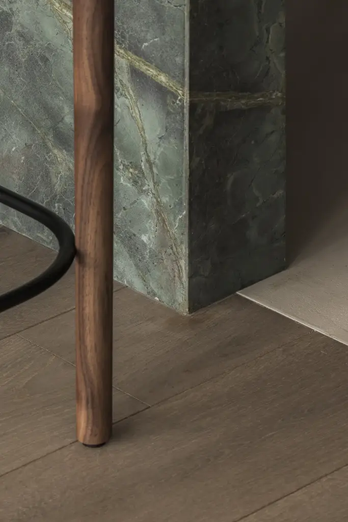 Houten poot naast een groen marmeren eiland, Appartement in Knokke, interieur Laura Calleeuw