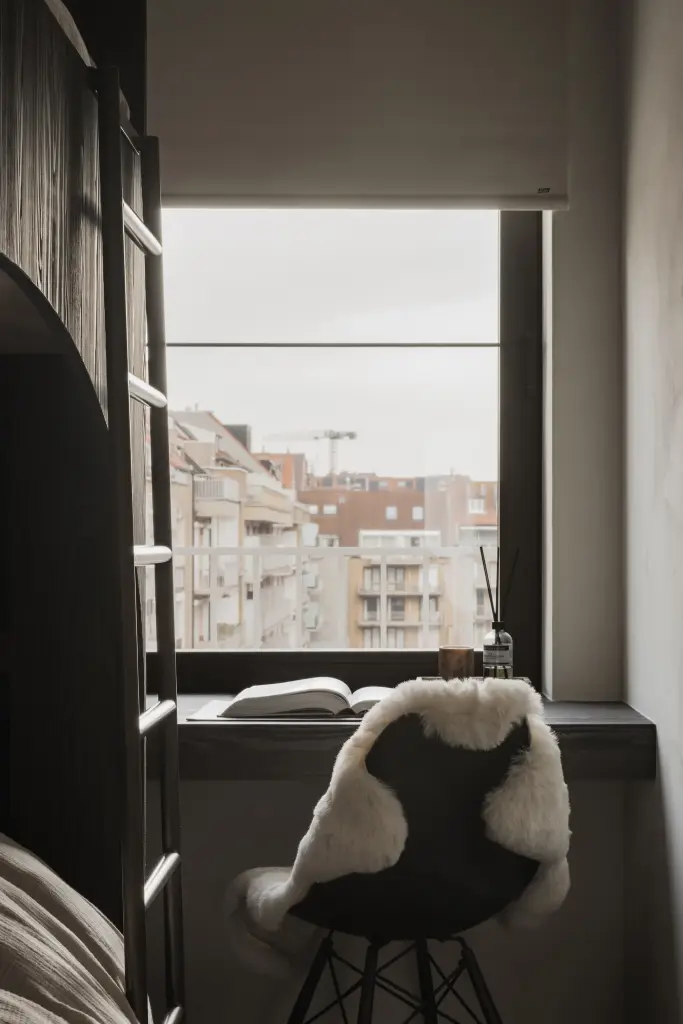 Kinderkamer met stapelbed in donker hout, bureautje en uitzicht op de stad, Appartement in Knokke, interieur Laura Calleeuw