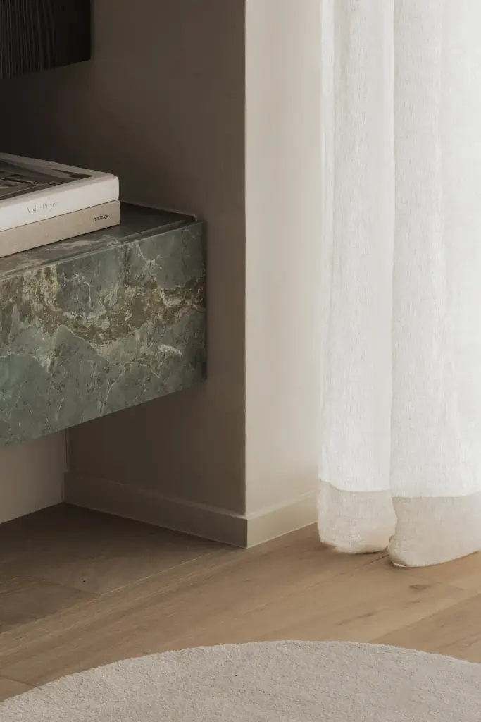 Groen marmeren plint naast een gordijn, Appartement in Knokke, interieur Laura Calleeuw