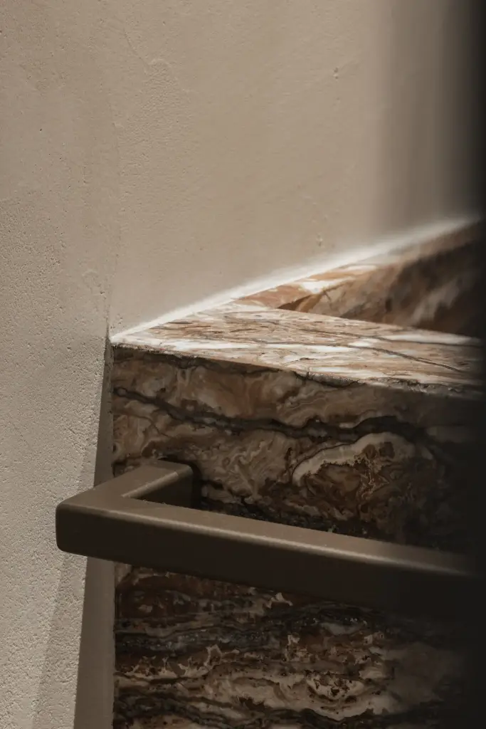 Detail van een onyx wastafelblok met bronzen handdoekstang, Appartement in Knokke, interieur Laura Calleeuw