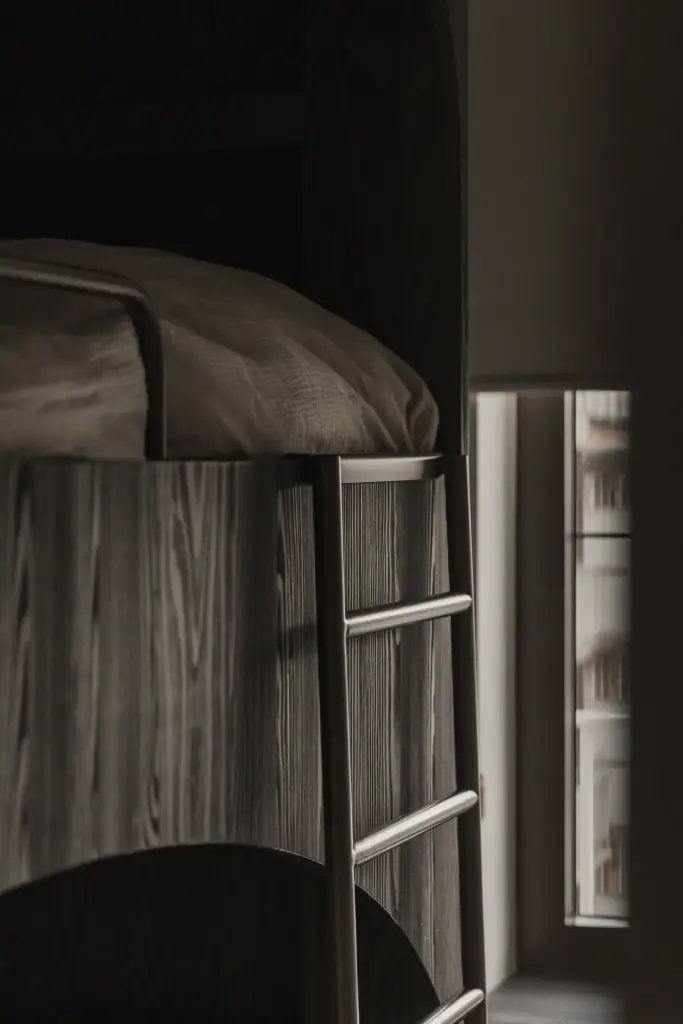 Detail van een stapelbed met ladder in donker hout, Appartement in Knokke, interieur Laura Calleeuw