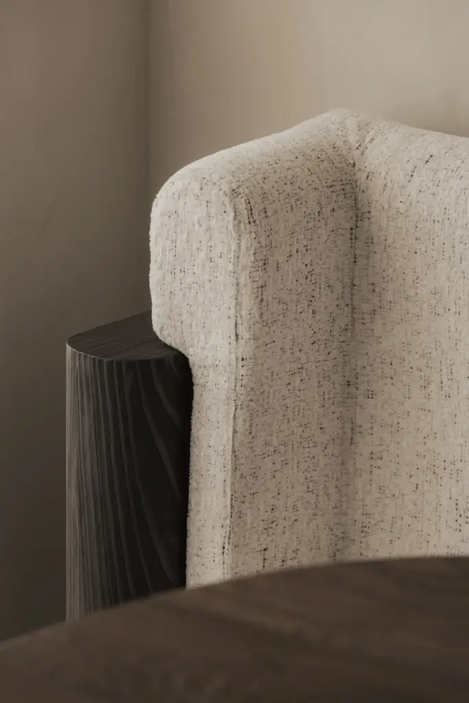 Detail van een bouclé stoel met houten voet, Appartement in Knokke, interieur Laura Calleeuw