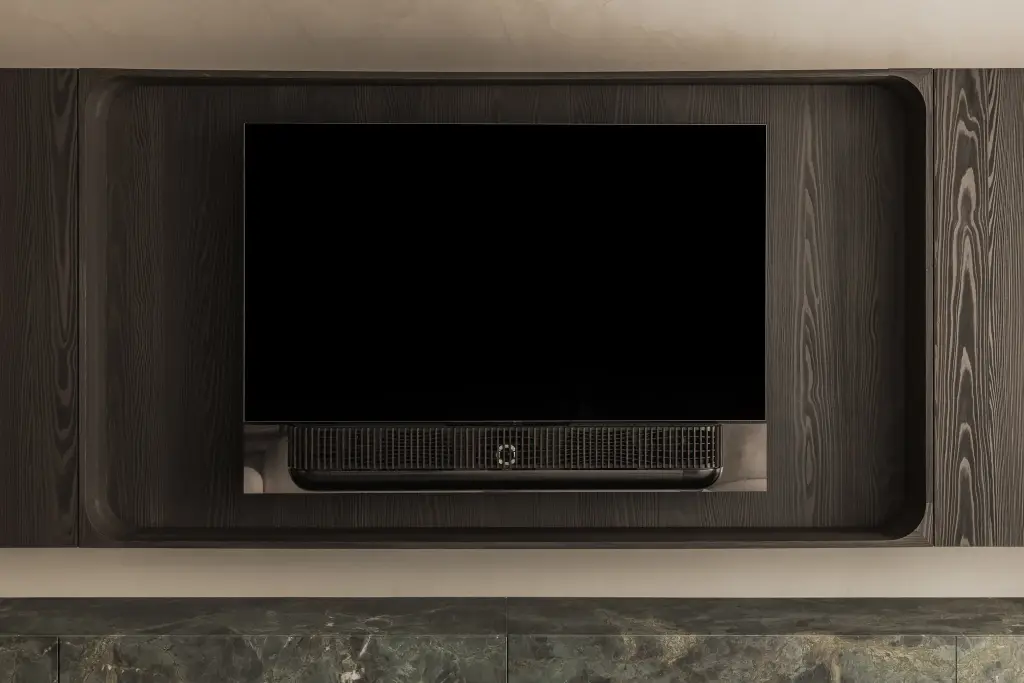Televisie in een afgeronde nis van donker eiken boven een marmeren plank, Appartement in Knokke, interieur Laura Calleeuw