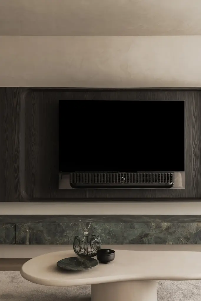 Televisie in een afgeronde nis van donker eiken boven een marmeren plank, Appartement in Knokke, interieur Laura Calleeuw