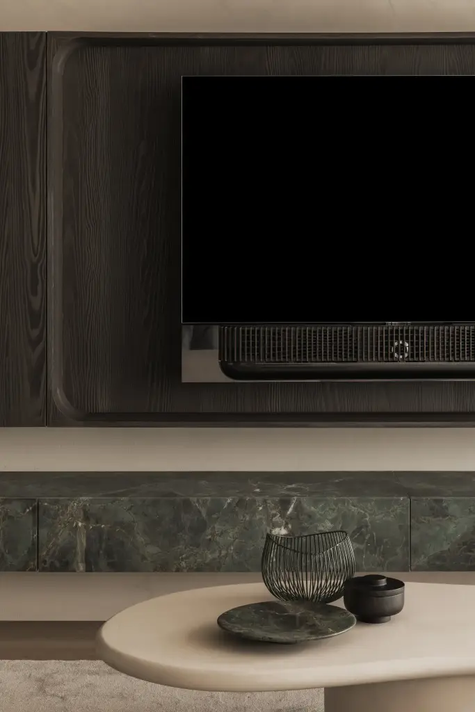 Televisie in een afgeronde nis van donker eiken boven een marmeren plank, Appartement in Knokke, interieur Laura Calleeuw