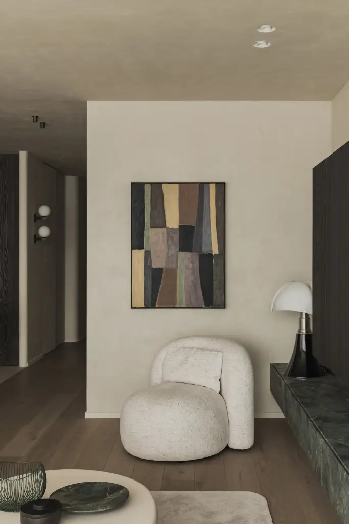 Zithoek met bouclé fauteuil, vloerlamp en televisiewand in donker eiken, Appartement in Knokke, interieur Laura Calleeuw